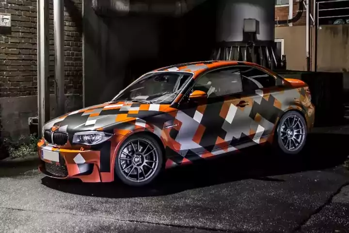 Oracle Signs Texas - BMW wrapped in an orange, gray and black pixelated pattern.
